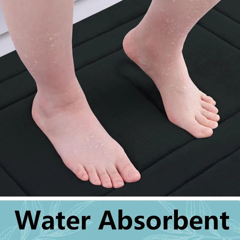 A close-up of a foot resting on a black absorbent bath mat, showing skin texture and water absorption.