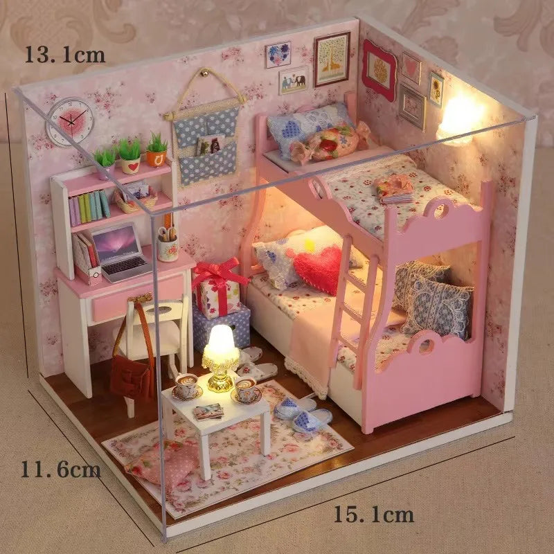 A miniature pink wooden dollhouse building kit featuring a bed, furniture, and decorative elements.