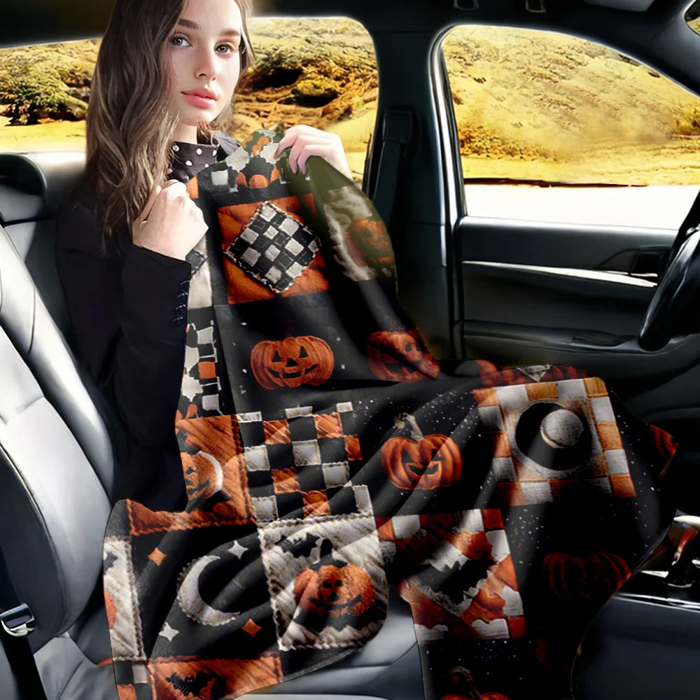 A woman sits in a car, holding a vintage patchwork Halloween throw blanket featuring pumpkin and moon prints.