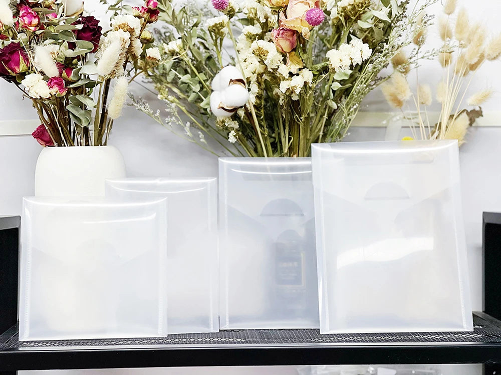 A set of clear plastic stamps and die for card making displayed in front of a floral arrangement.