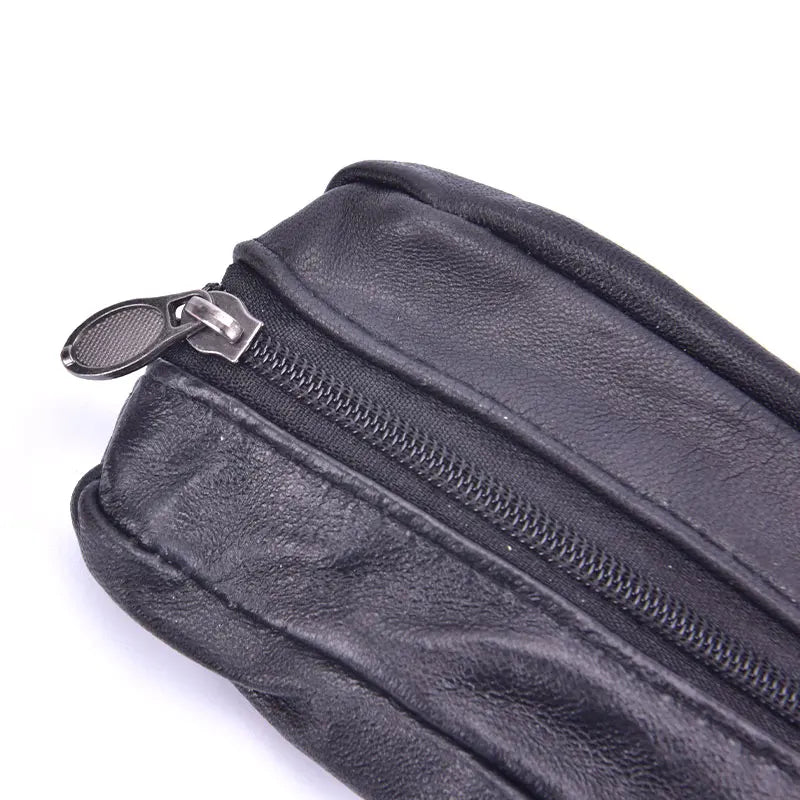 A close-up view of a black leather compact zippered coin purse with a metal key holder.