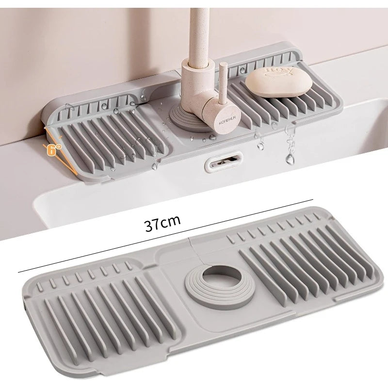 A gray silicone faucet splash mat is shown mounted on a white surface, demonstrating its use in the kitchen or bathroom.