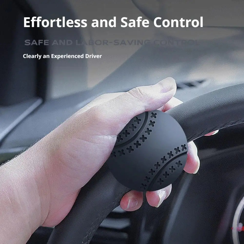 A hand grips a black steering wheel knob designed for effortless one-hand control.