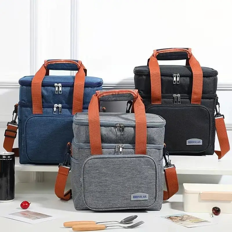 A gray insulated lunch bag with orange straps is displayed next to a dark blue one on a white surface.