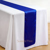 Elegant satin blue table runner draped across a white tablecloth.