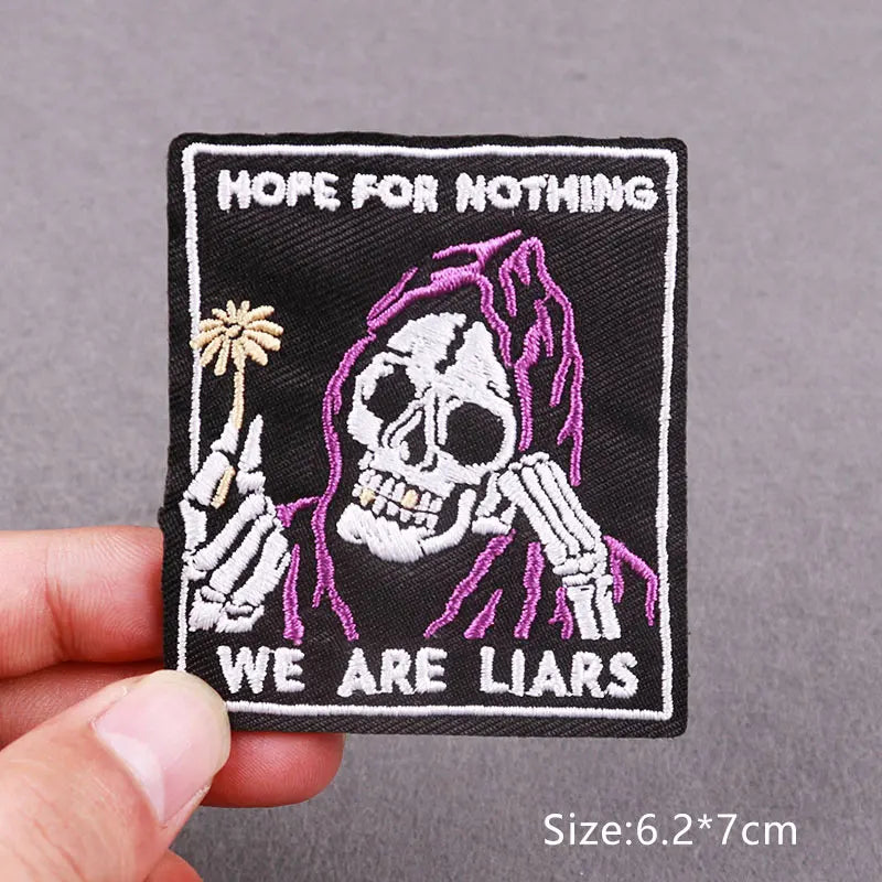 Black embroidered patch featuring a skull with hands near its face and the text HOPE FOR NOTHING WE ARE LIARS