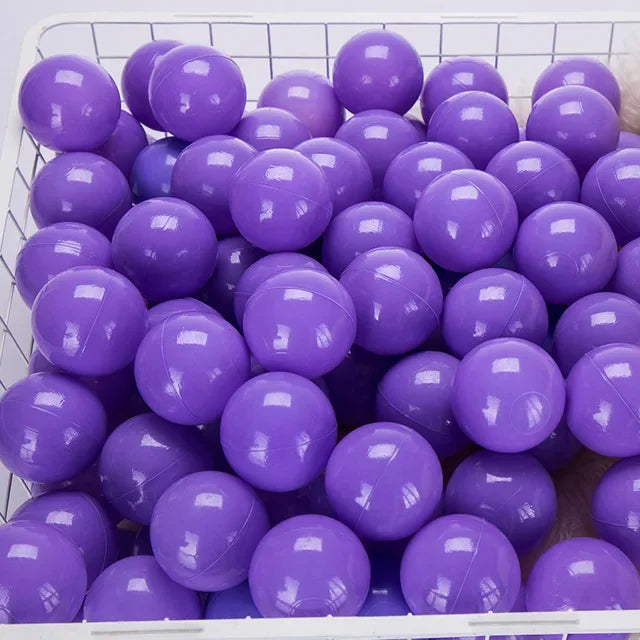 A white basket filled with purple plastic ball pit balls for toddlers and kids.