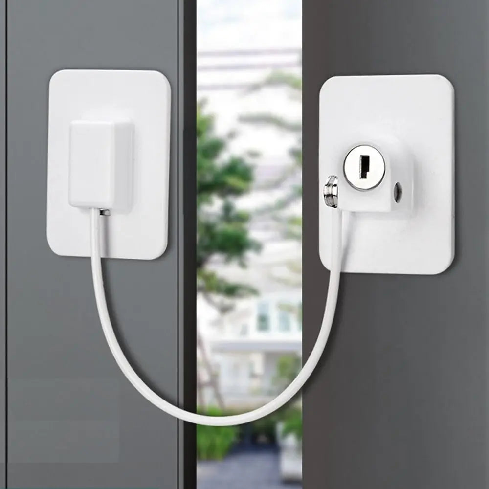 A white self-adhesive window safety lock with two keys mounted on a gray door frame.