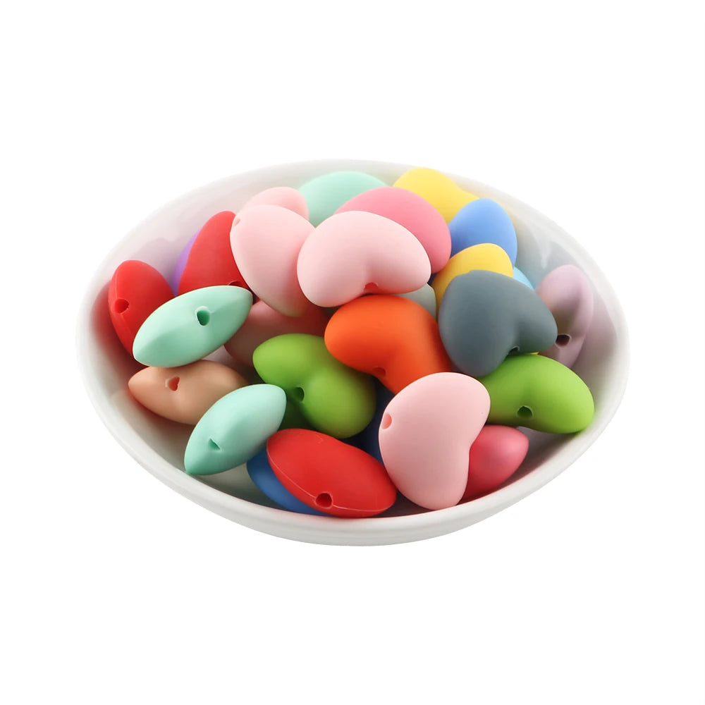 A collection of ten colorful silicone heart beads in various shades of pink, green, yellow, and blue for DIY jewelry making.