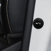 A close-up view of a black sound insulation pad or shock-absorbing door cushion with an emblem on a white surface.