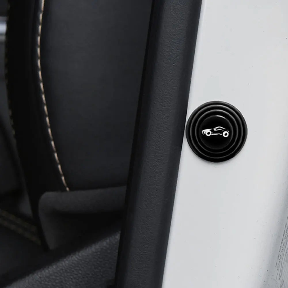 A close-up view of a black sound insulation pad or shock-absorbing door cushion with an emblem on a white surface.