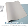A double-sided light beige leather desk mat shown next to a white keyboard.