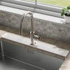 A modern stainless steel faucet mounted on a kitchen sink, with a rectangular stone tray for fast-drying water absorption.