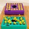 A purple timing puzzle toy board and a green matching game with yellow puzzle pieces on a wooden surface.