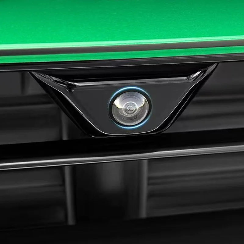 A close-up view of a black protective cover for a car camera, featuring a round lens with blue illumination.