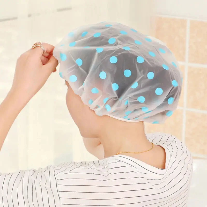 A woman is wearing a light blue sheer shower cap with white polka dots and a striped shirt.