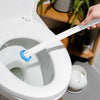 A hand is holding a white toilet brush with a long handle, positioned inside a white toilet bowl.