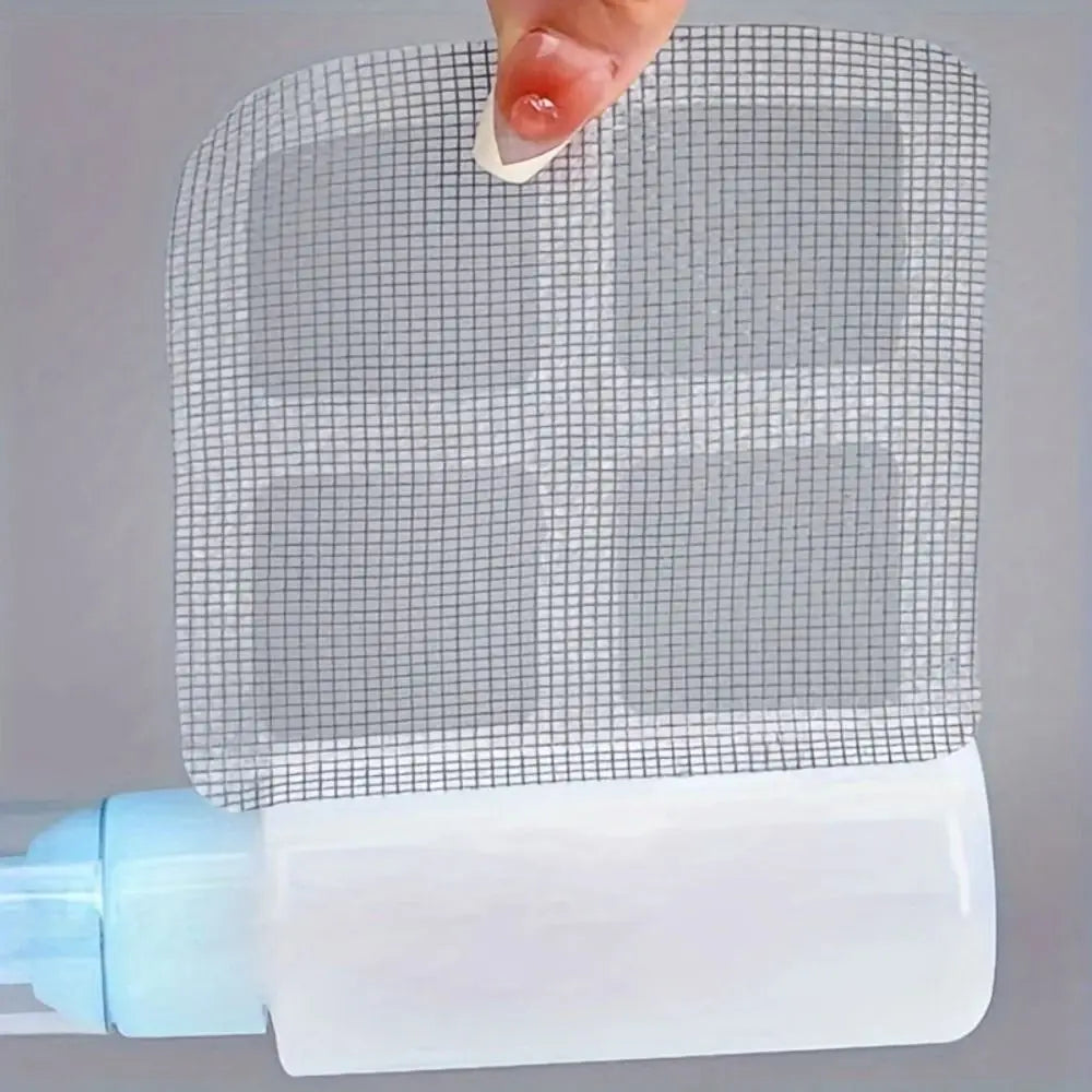 A hand is placing a disposable drain hair catcher sticker onto a white plastic bottle.