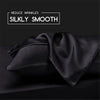 Black silky smooth satin fabric draped on a dark surface for hair and skin care.