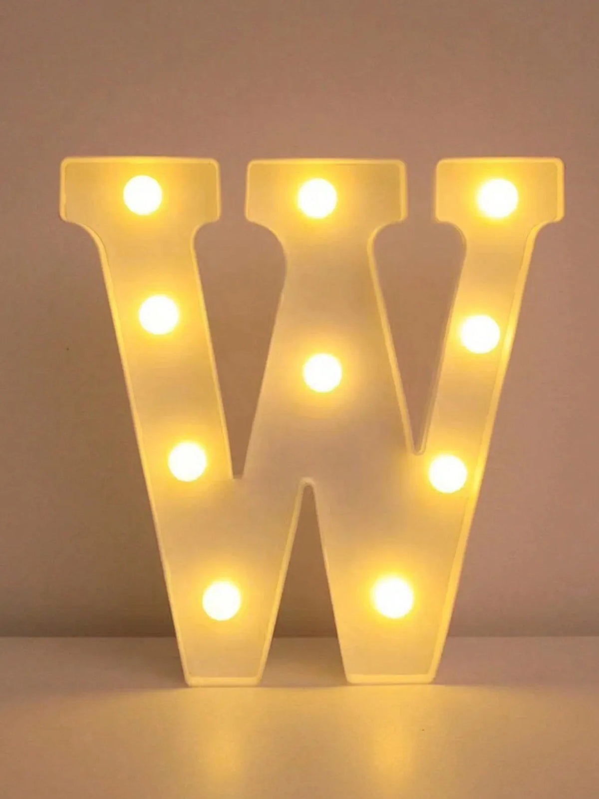 A glowing white LED letter night light shaped like the letter W, featuring multiple illuminated bulbs.
