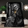 A black and white print featuring a skull and biker imagery on a blanket.