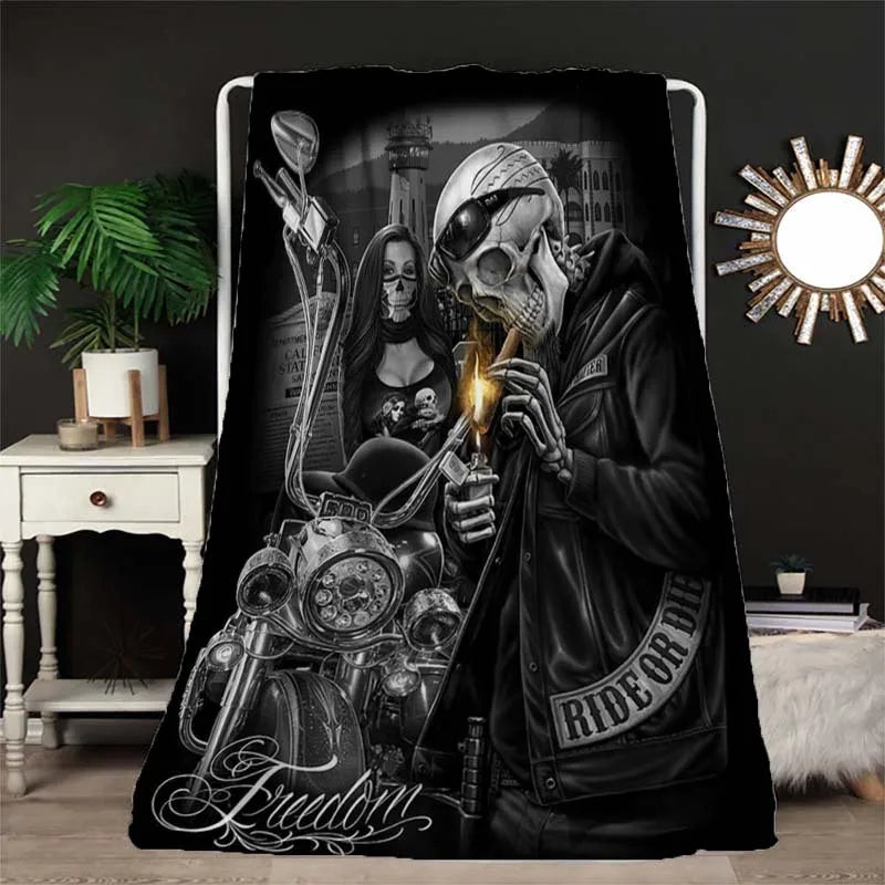 A black and white print featuring a skull and biker imagery on a blanket.