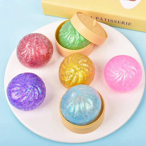 Collection de gâteaux squishy colorés et brillants sur une assiette blanche.