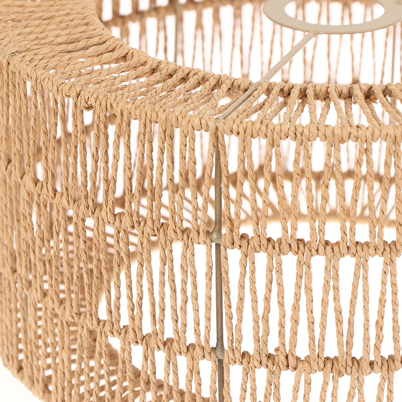 A close-up of a woven paper rope lampshade with fringe, made from natural beige material.