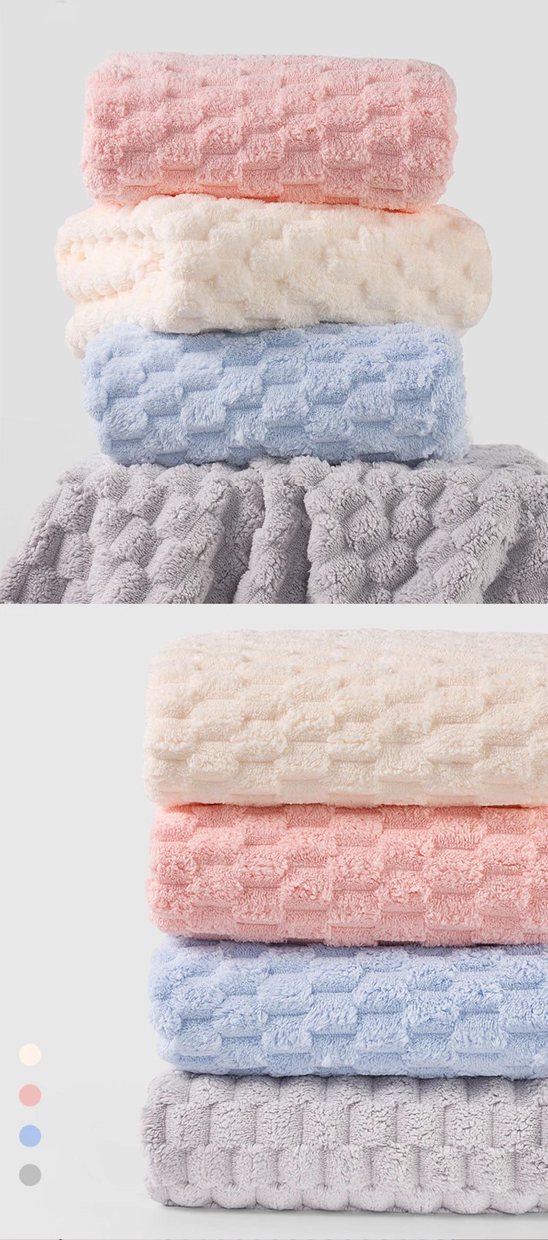 A stack of four plush bath towels in shades of pink, white, blue, and gray.