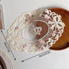 Elegant oval white lace embroidery wreath on a wooden placemat