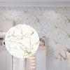 Marble effect peel-and-stick wallpaper covering a kitchen wall with white and gold veining.