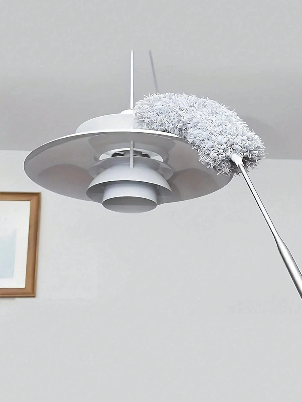 A white flexible microfiber duster with a fluffy gray head is suspended from a rod.