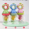 Three silicone baby fruit feeders in green, blue, and pink with dinosaur designs for different months of age.