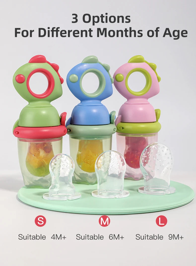 Three silicone baby fruit feeders in green, blue, and pink with dinosaur designs for different months of age.