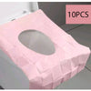 Ten pink disposable toilet seat covers folded and displayed on a white surface.