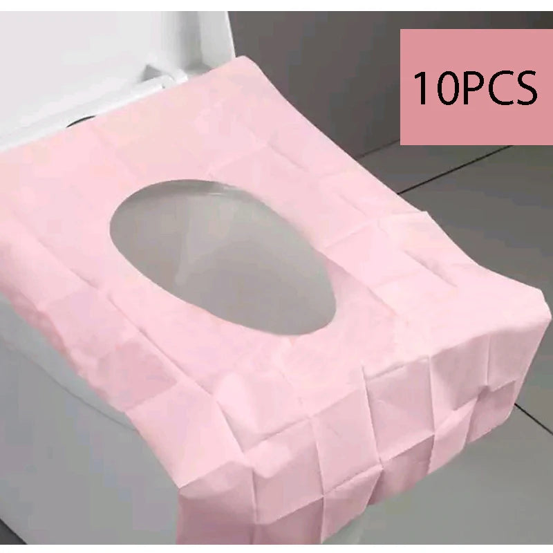 Ten pink disposable toilet seat covers folded and displayed on a white surface.