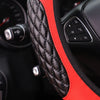 Close-up of a black quilted steering wheel cover with a red accent, showing controls and stitching.