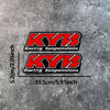 Two black and red decals featuring the KYB Racing Suspensions logo on a gray textured background.