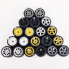 A collection of ten pairs of 1:64 scale alloy car wheels and tires stacked in a pyramid formation.