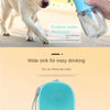 A light blue portable pet water bottle with a spout is shown being held by a hand, next to a dog.