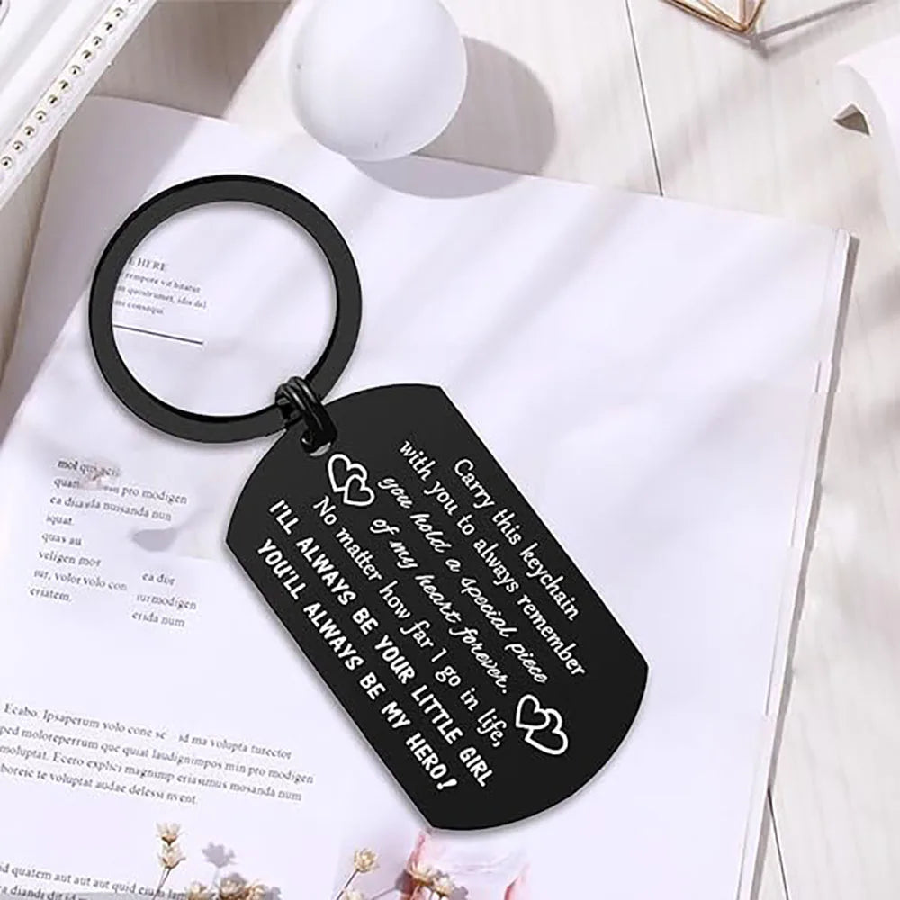 Black leather keychain with a heart charm attached to a white paper background.