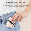 A hand is inserting a small, light-colored protective capsule case into the pocket of blue jeans.