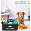 A black felt storage basket labeled Dog Toys filled with various colorful dog toys on a white surface.