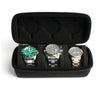 A black portable leather watch travel case with soft lining holding three wristwatches.