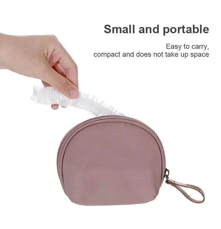 A hand is holding a small, pink disposable shower cap with an elastic edge.