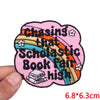 Pink embroidered patch with a rainbow design featuring text about chasing that scholastic book fair high