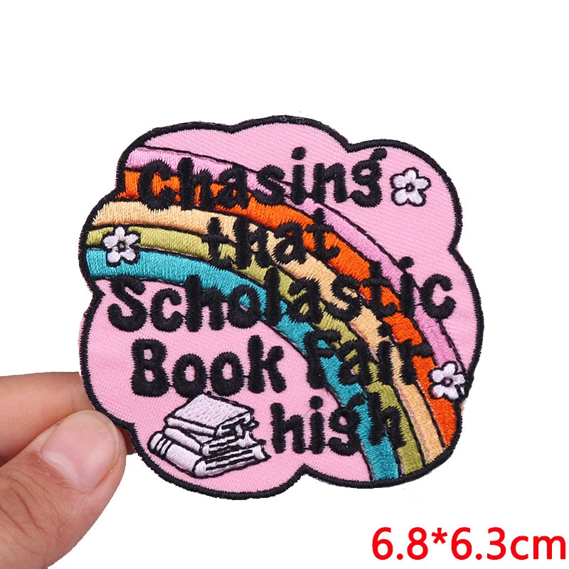 Pink embroidered patch with a rainbow design featuring text about chasing that scholastic book fair high