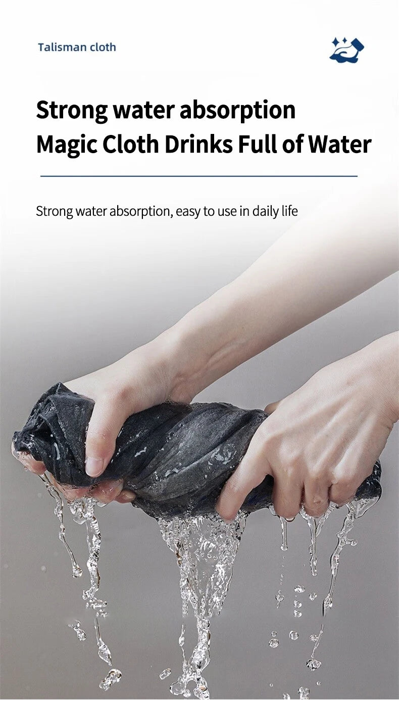 A hand is squeezing a dark cloth that is dripping water, demonstrating strong water absorption.