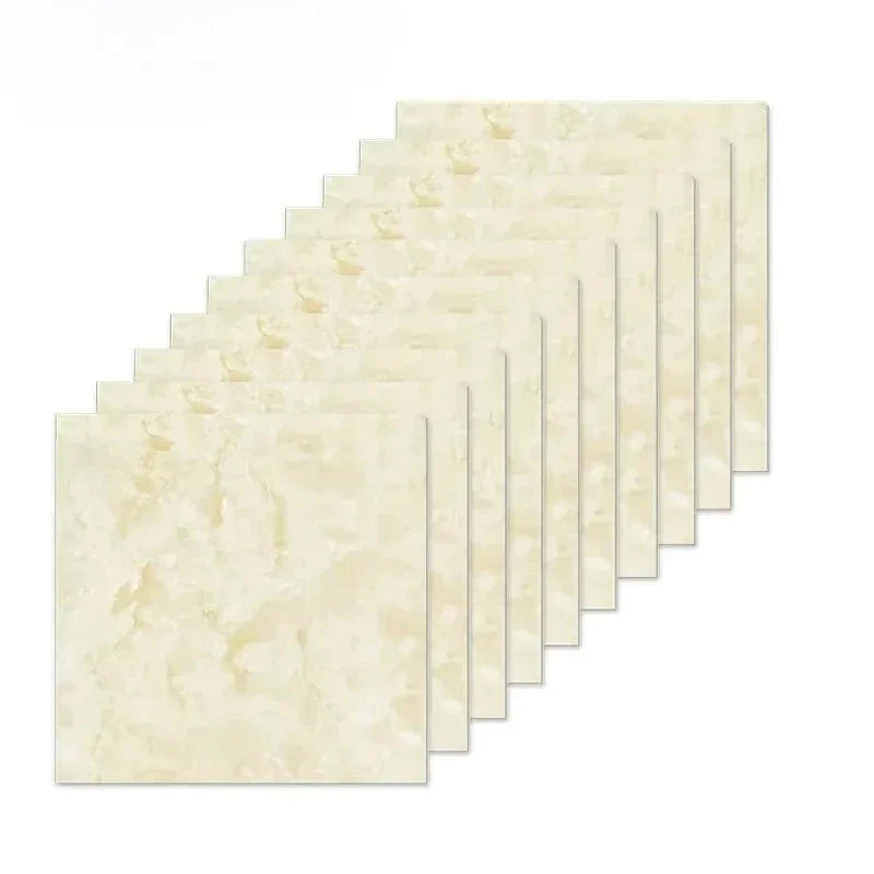 A stack of rectangular, light beige marble peel-and-stick wall tiles shown at an angle.