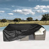 Black waterproof patio furniture cover placed on a white surface with a wicker cushion.